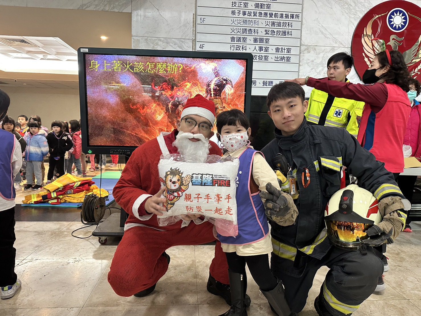 打火兄弟扮成聖誕老公公致贈小禮物給參訪消防隊的小朋友。(圖/基隆市政府提供)