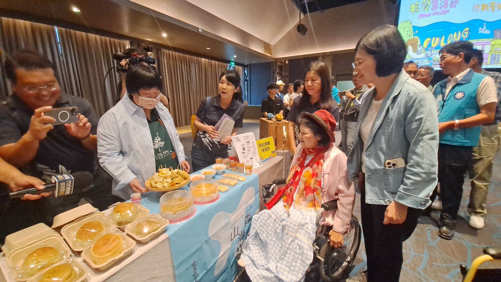 活動現場也邀請在地創意店家到場參加,東北角管理處遊憩科長辛靜如(左3)一一為來賓介紹這些文創商品與美食,並提供給來賓試吃品嚐。
