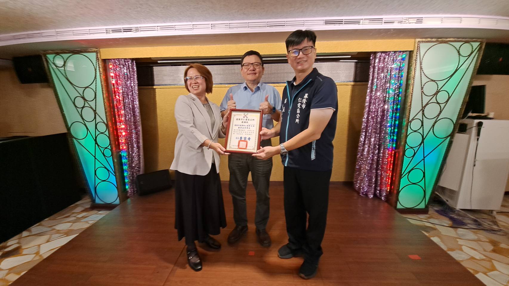 基隆市政府仁愛區公所區長李宗奇((右1)特別致贈感謝狀給卸任理事長亷貴晶(左1)，基隆市政府秘書長方定安(中)，也一起陪同感謝廉理事長長期對區公所的協助。