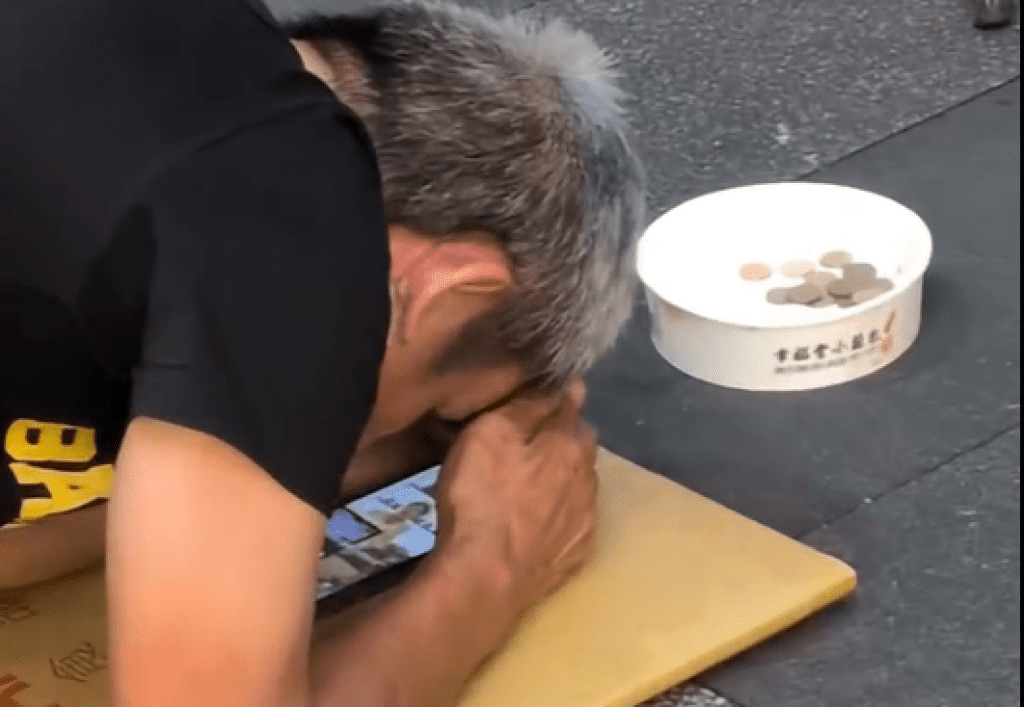 影／這樣行乞的！阿伯跪下頭碰地「眼前放手機追劇」　網酸：上班不要偷看