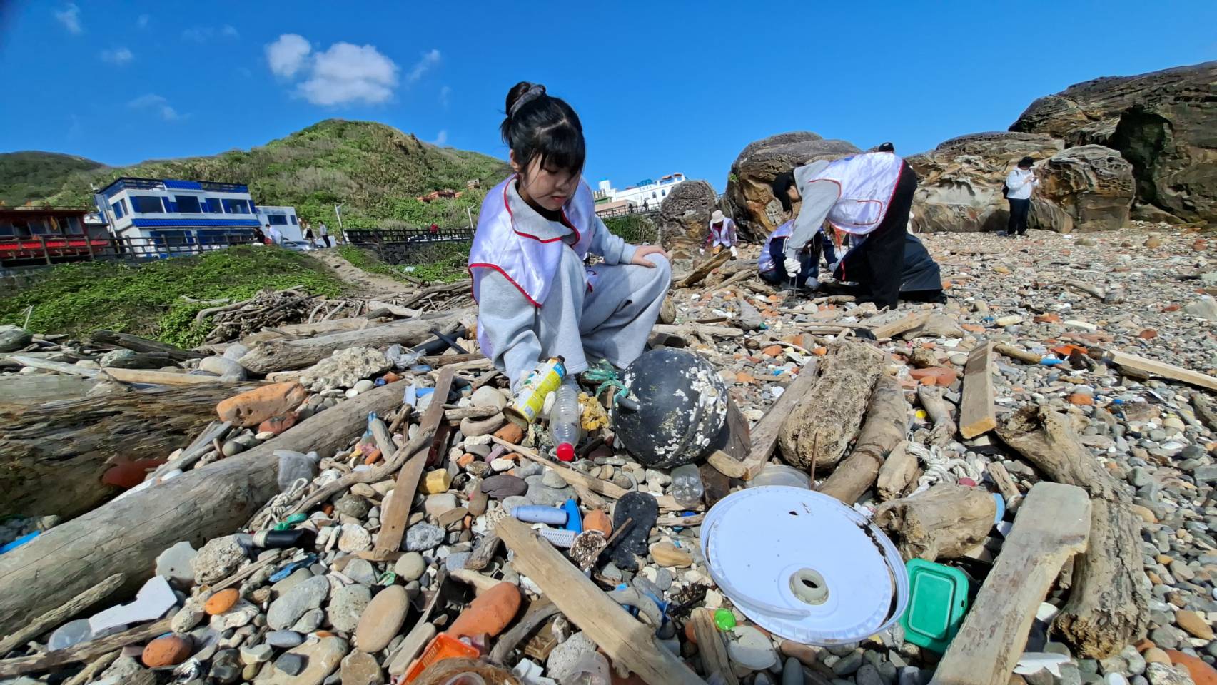 負責這次青年節活動攝影的二信高中代表籌備委員呂亞靜利用拍照玩的時間,也跟大家一樣捲起衣袖開始協助淨灘。